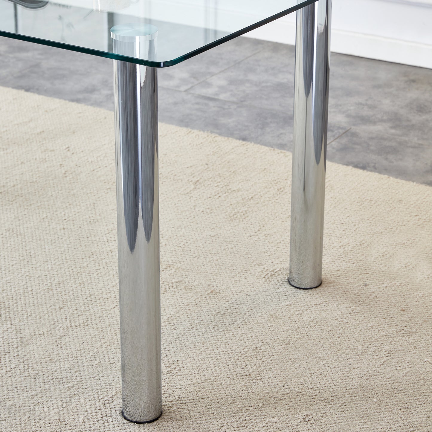 A modern minimalist style glass dining table. Transparent tempered glass tabletop with a thickness of 0.3 feet and silver metal legs. Suitable for restaurants and living rooms. 63 "* 35.4" * 30"